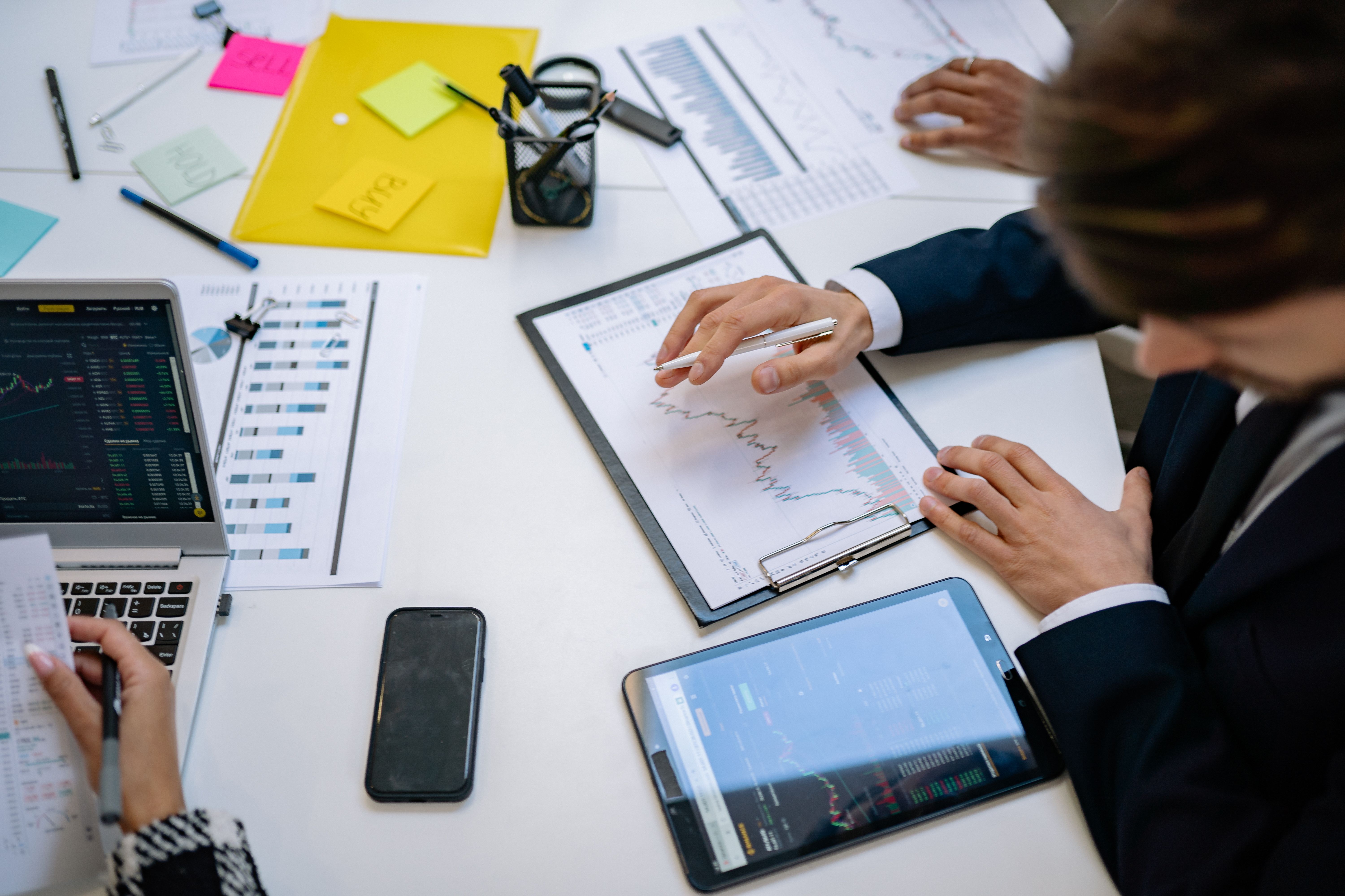 Financial reporting services shown with an income statement, balance sheet, and cash flow charts on a business owner's desk.